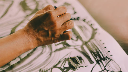 High angle view of woman hand holding leaf