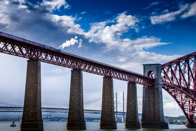Low angle view of forth bridge over firth of forth against sky