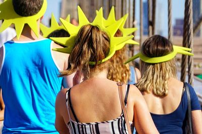 Rear view of people wearing headdress walking on bridge