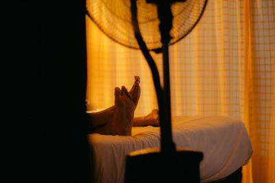 Shadow of woman hand on bed at home