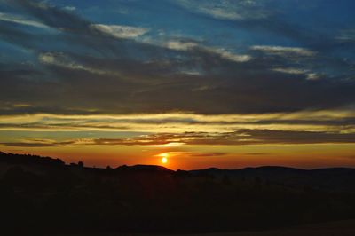 Scenic view of silhouette mountains against sky during sunset