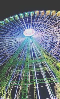 Low angle view of illuminated ferris wheel against sky at night