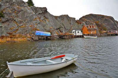 Boat moored in lake by building