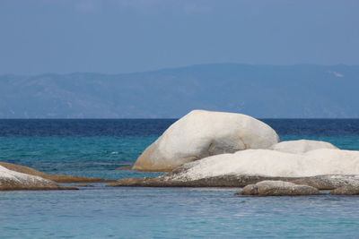 Scenic view of sea against sky with a white island