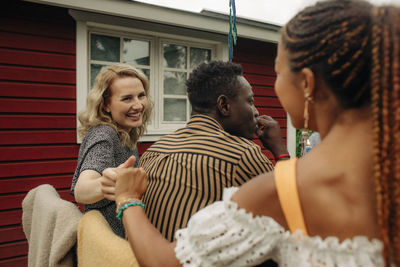 Happy female friends holding hands while looking at each other