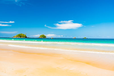 Scenic view of beach against blue sky