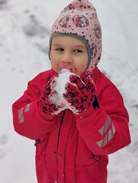 Portrait of cute girl standing on snow