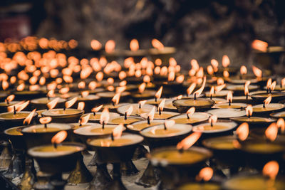 Burning lit tea light candles in temple