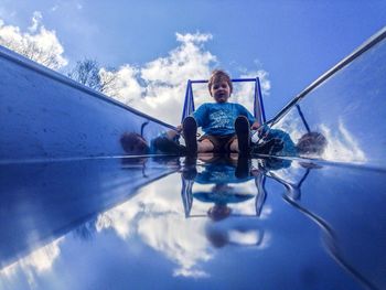 Low angle view of people against clear blue sky