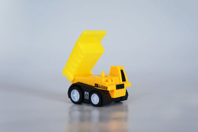 Close-up of yellow toy car over white background