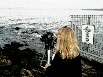 Woman photographing sea