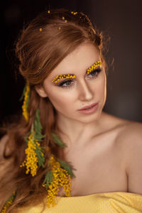 Portrait of a young woman in yellow mimosa flowers