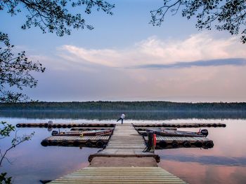 Pier on lake against cloudy sky