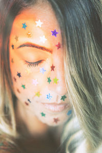 Close-up of young woman with star shape glitters