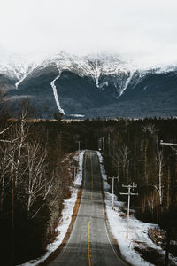 Snow covered road passing through mountain