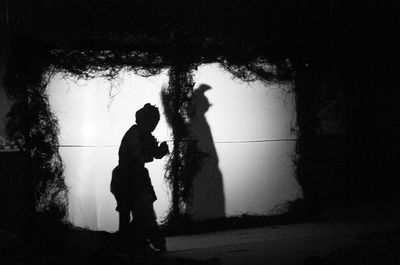 Silhouette people standing by tree against sky