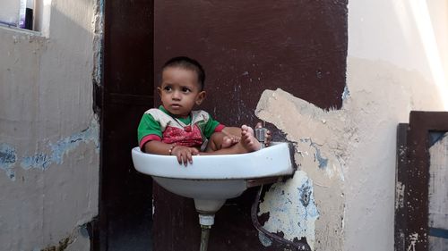 Baby girl sitting in sink