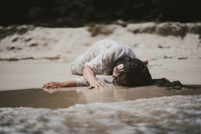 Side view of woman laying on the beach 