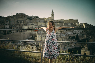 Rear view of young girl standing against old european city