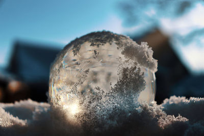 Close-up of frozen ball against sky