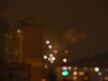 Defocused image of illuminated lights in city at night