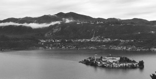 Scenic view of sea by mountains against sky