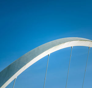 Low angle view of bridge against clear blue sky