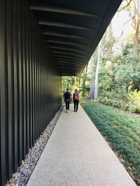 Rear view of people walking on footpath