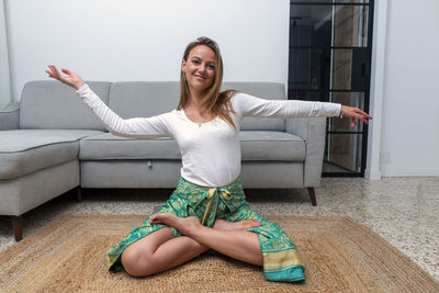 Young blonde woman practicing yoga at home