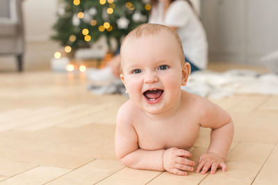 Portrait of cute baby boy lying on floor