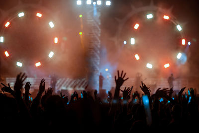 Crowd with arms raised enjoying at music concert