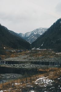 Scenic view of lake by mountains against sky