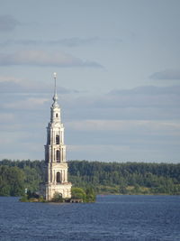 View of lighthouse by sea against sky