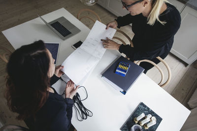 High angle view of woman using laptop on table