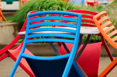 Close-up of wet colorful chairs arranged outdoors