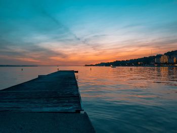 Pier over sea against sky during sunset