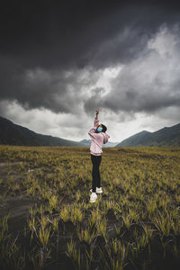 Woman standing on field against sky