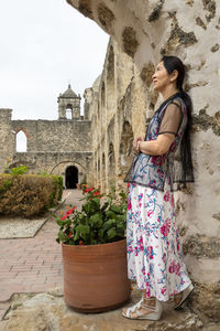 Woman standing by potted plants