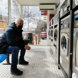 Man sitting in front of washing machines