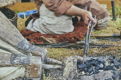 The blacksmith warms up the workpiece with bellows at viking festival in denmark