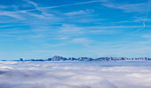 Scenic view of snowcapped mountains by sea against sky