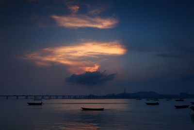 Boats in sea at sunset