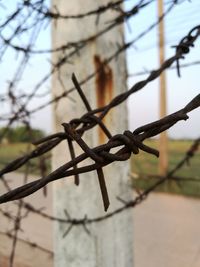 Close-up of barbed wire against sky