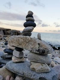 Stack of pebbles on beach against sky