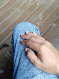 Close-up of person hand against blue wall