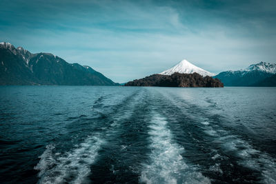 Scenic view of sea and mountain against sky during winter