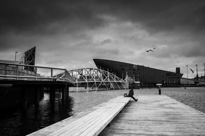 Bridge over pier against sky in city