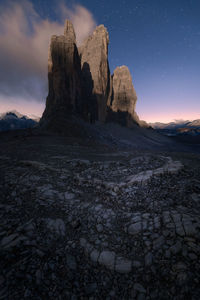 Tre cime di lavaredo in the italian dolomites with full moon and a sky full of stars.