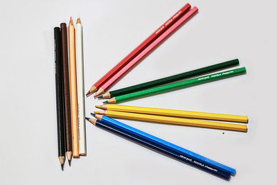 High angle view of colored pencils against white background