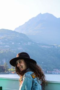 Portrait of young woman against mountains against sky